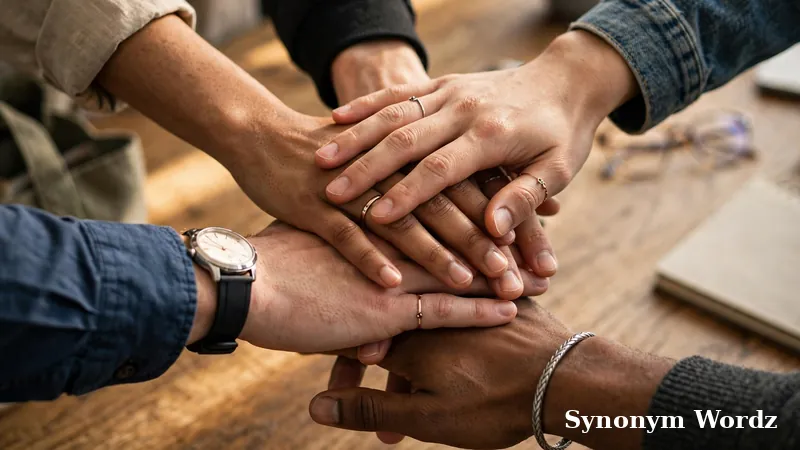 Team members stacking hands together in a show of collaboration and teamwork in a modern office