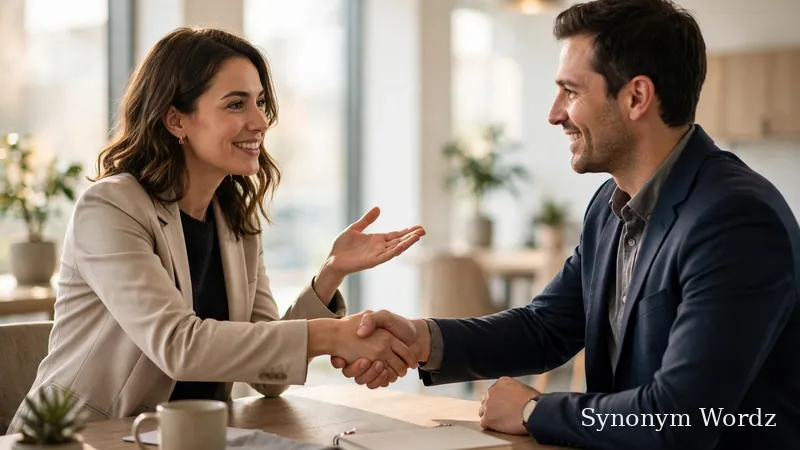Two professionals shaking hands across a desk during a friendly business networking meeting