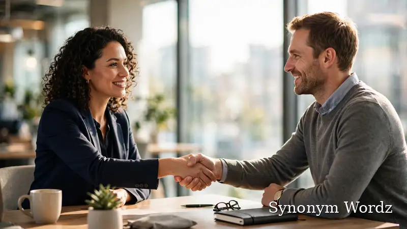 Two professionals shaking hands across a desk during a job interview