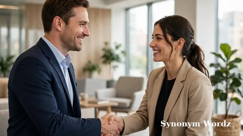 Two business colleagues shaking hands warmly in a bright office, a friendly professional greeting