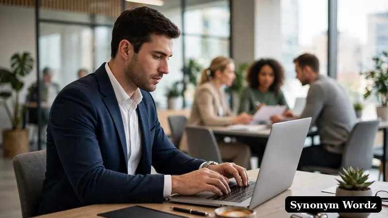 A professional writing a polished business email on a laptop in a modern office