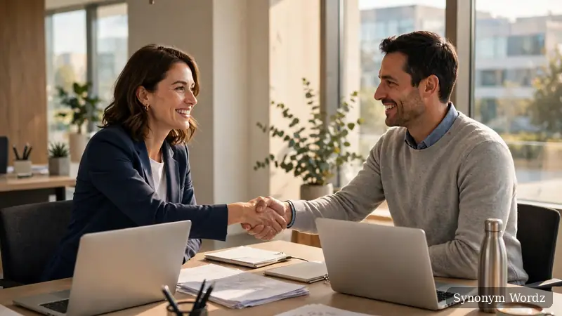 Two colleagues shaking hands in a bright modern conference room during a successful meeting