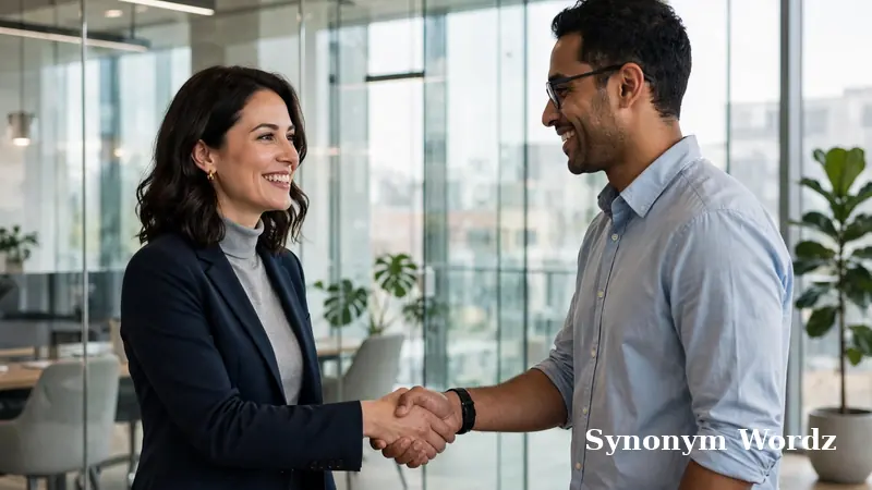 Coworkers shaking hands in a bright office, showing supportive workplace communication