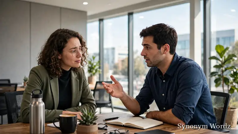 Two colleagues having a warm, supportive conversation in a modern office meeting room