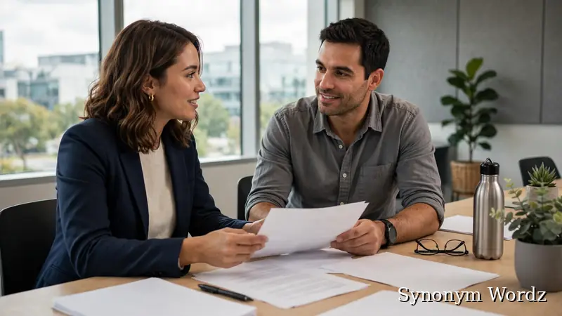 Two colleagues discussing documents during a meeting at work